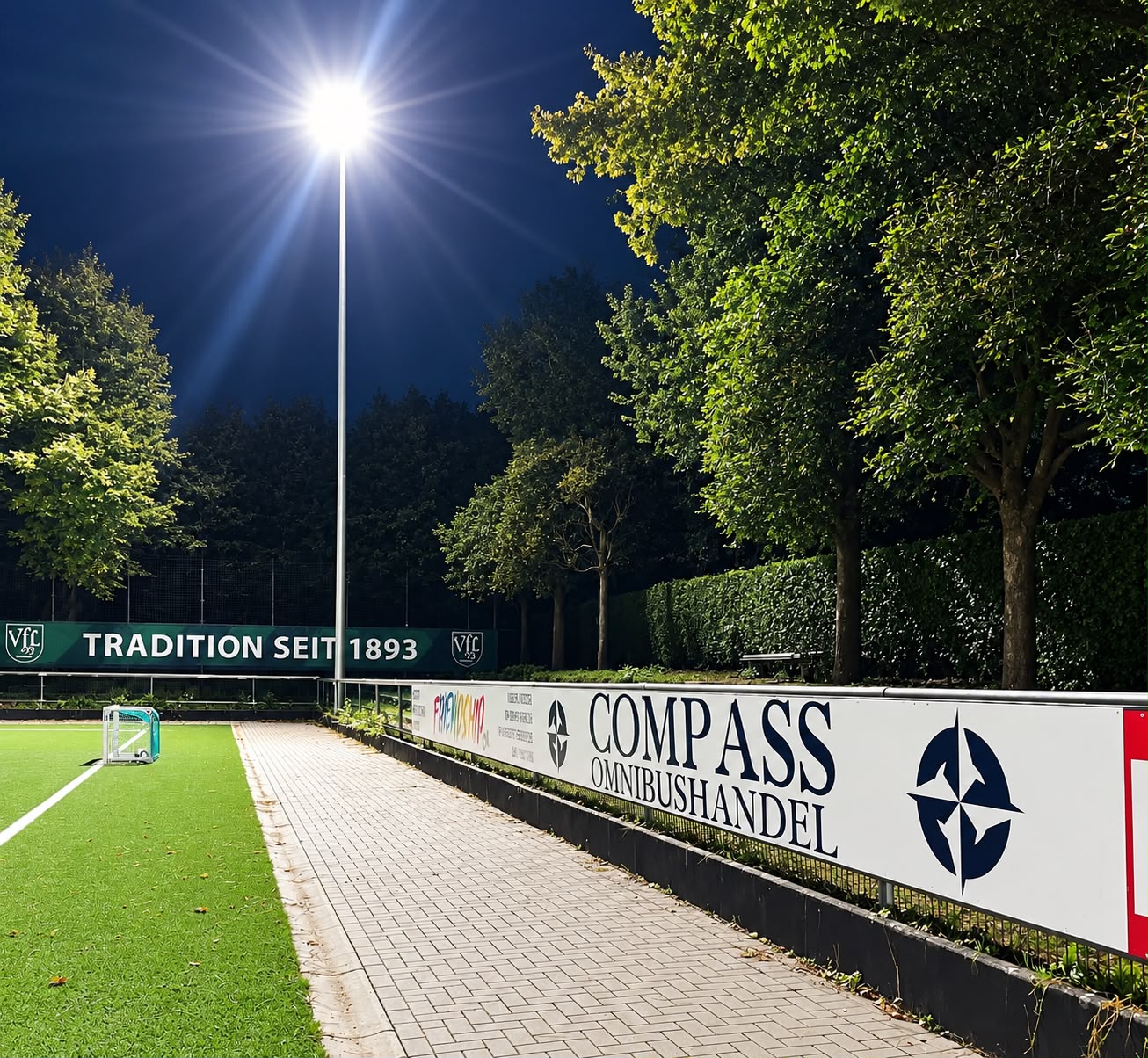 Bandenwerbung von Compass Omnibushandel am Sportplatz des VfL 93 Hamburg bei Flutlicht